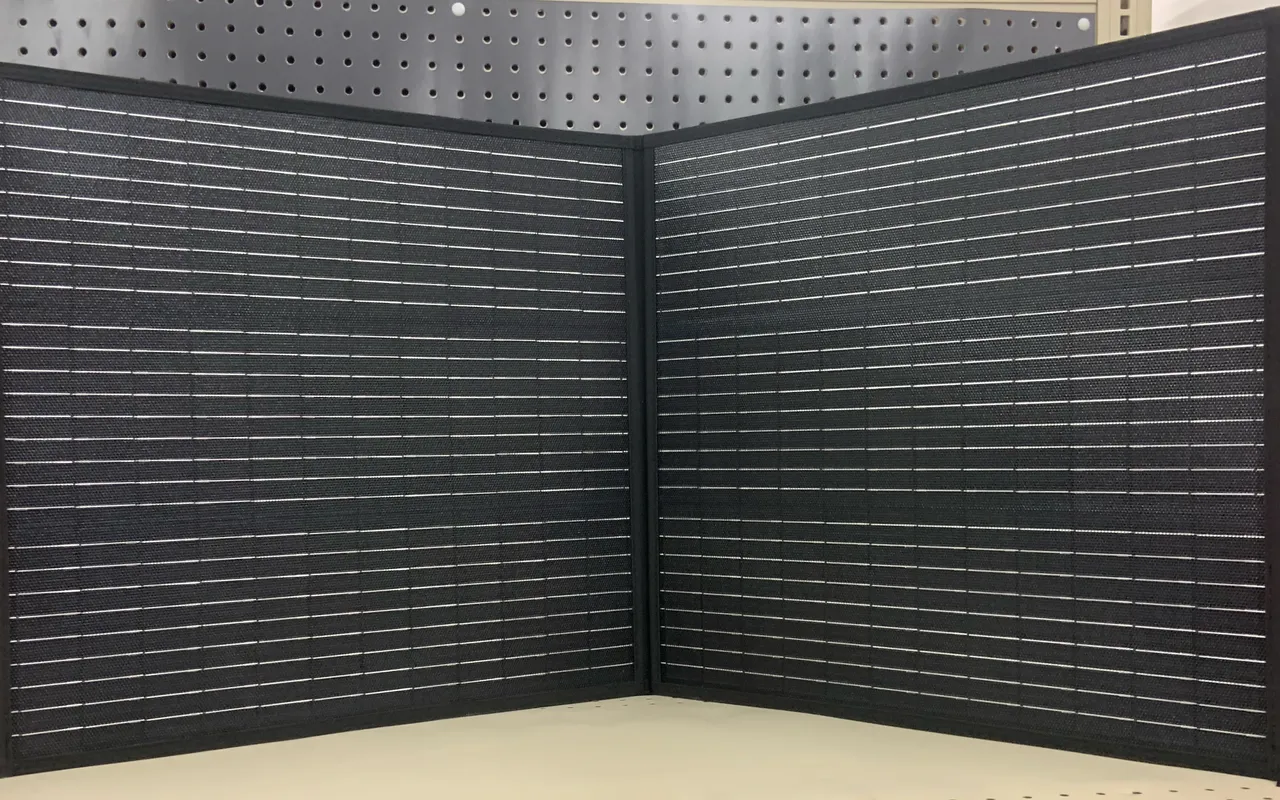 A black foldable solar panel standing open