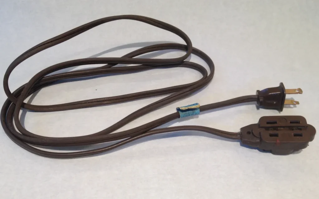 A brown household extension cord with a three-outlet end