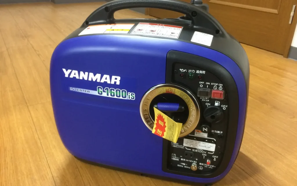 A compact blue Yanmar inverter generator on a wooden floor