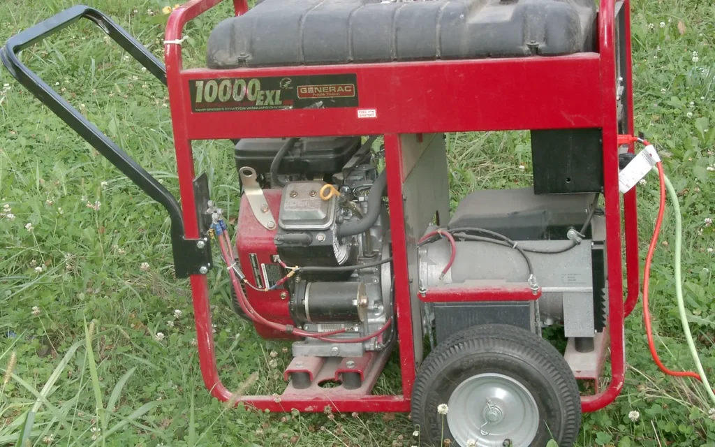 A red open-frame portable generator seen from the side, standing on grass