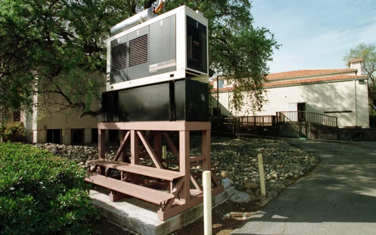 A standby generator installed on a raised wooden platform beside a building as flood protection