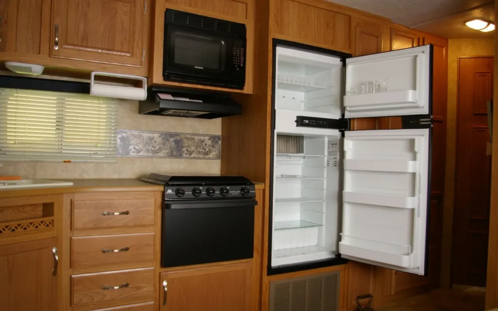 An RV slide-out kitchen with a refrigerator, microwave and stove